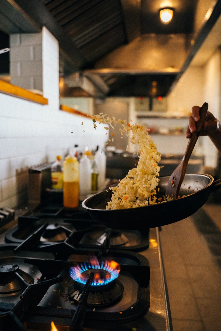 person cooking fried rice on frying pan